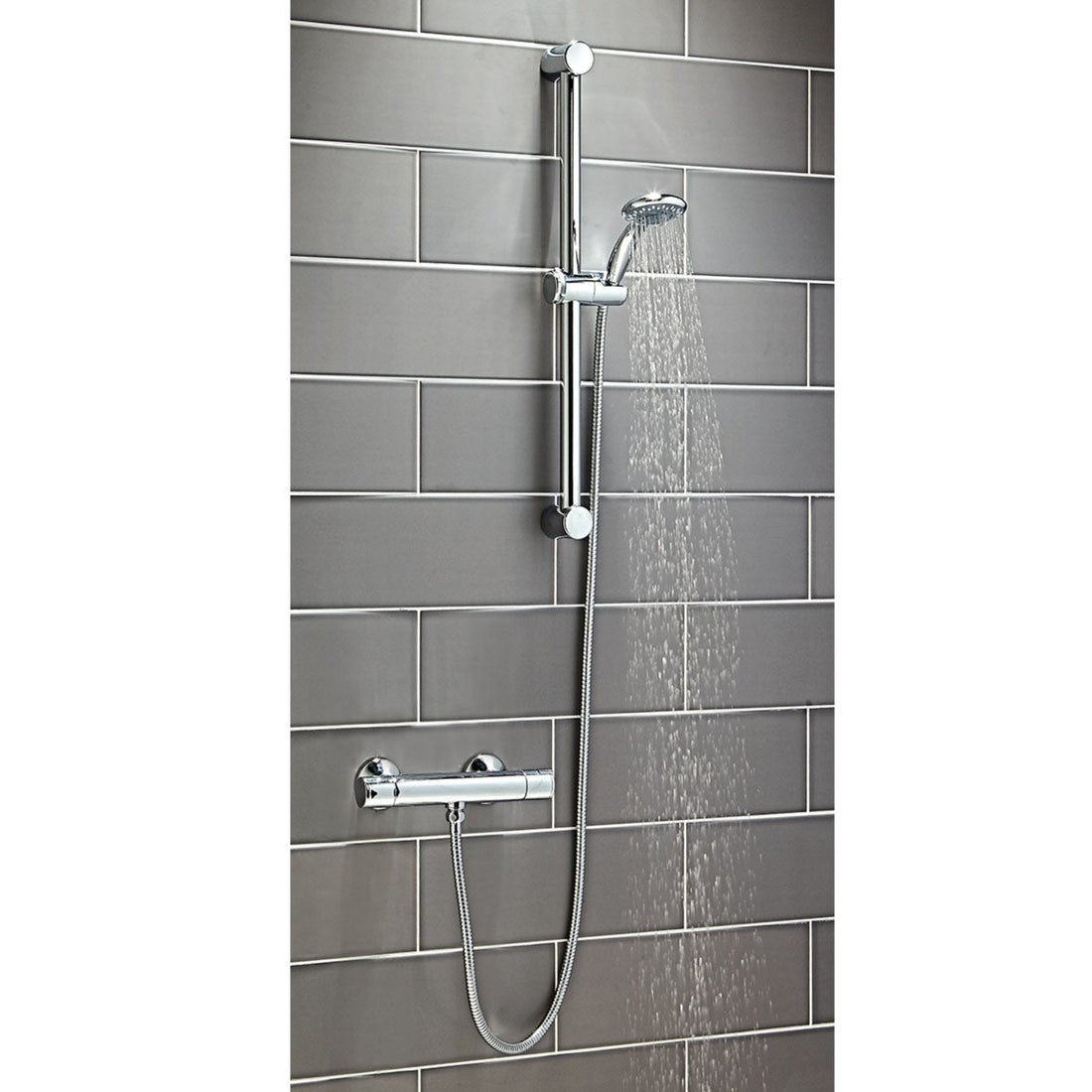 Shower system with handheld shower head and control handle on a tiled wall.