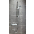 Shower system with handheld shower head and control handle on a tiled wall.