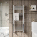 Towel radiator in a bathroom with tiled walls and a toilet.