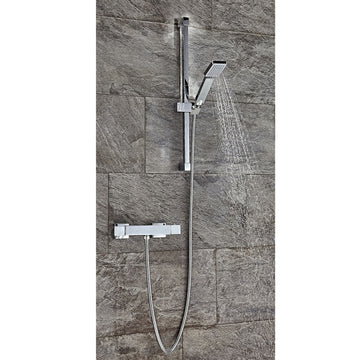 Chrome shower set with handheld shower and control handle mounted on a tiled wall.