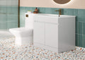 Bathroom setup with white vanity unit, toilet, and sink against a green tiled wall.
