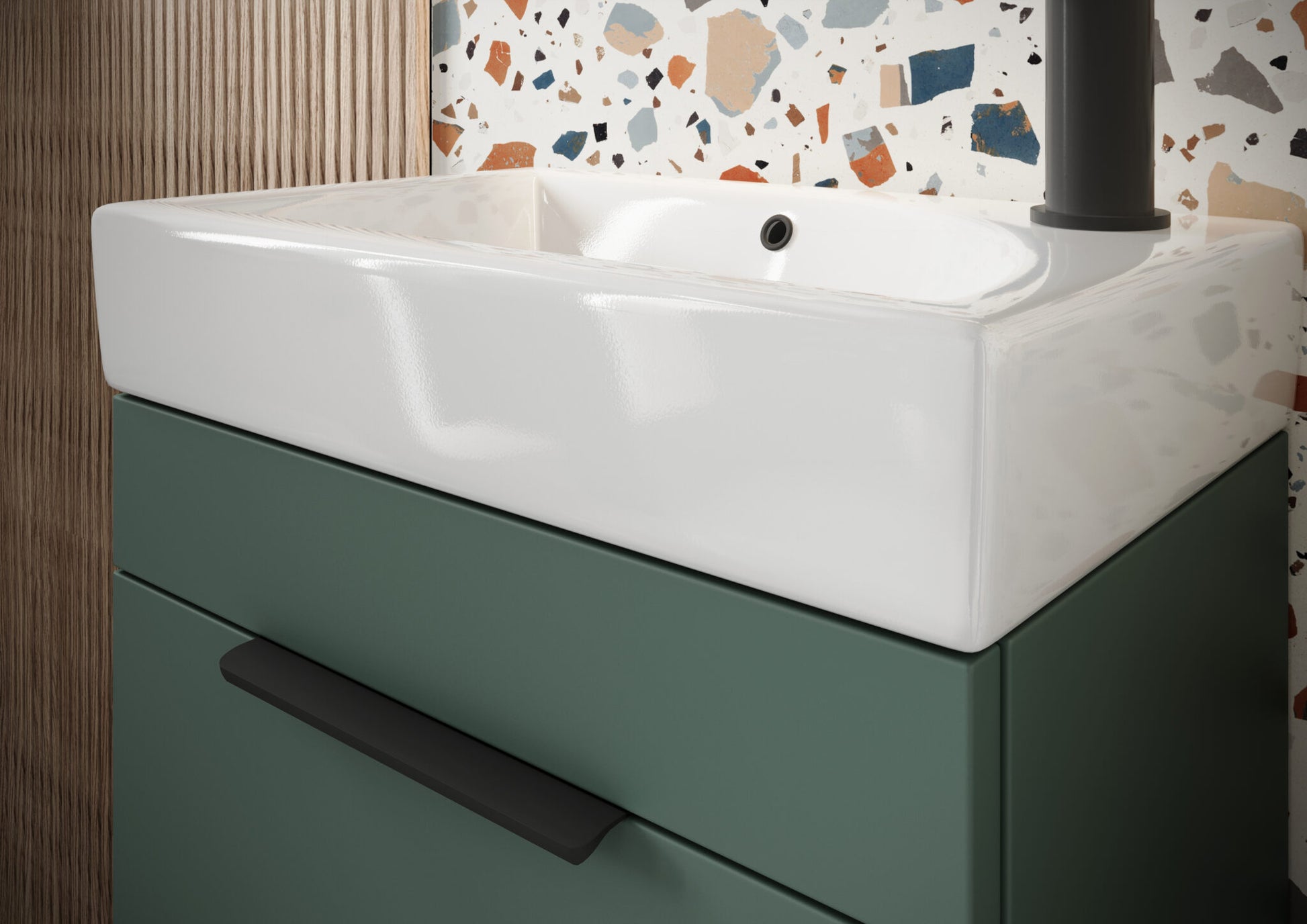 Bathroom vanity with white sink and green cabinet against a terrazzo-patterned wall.
