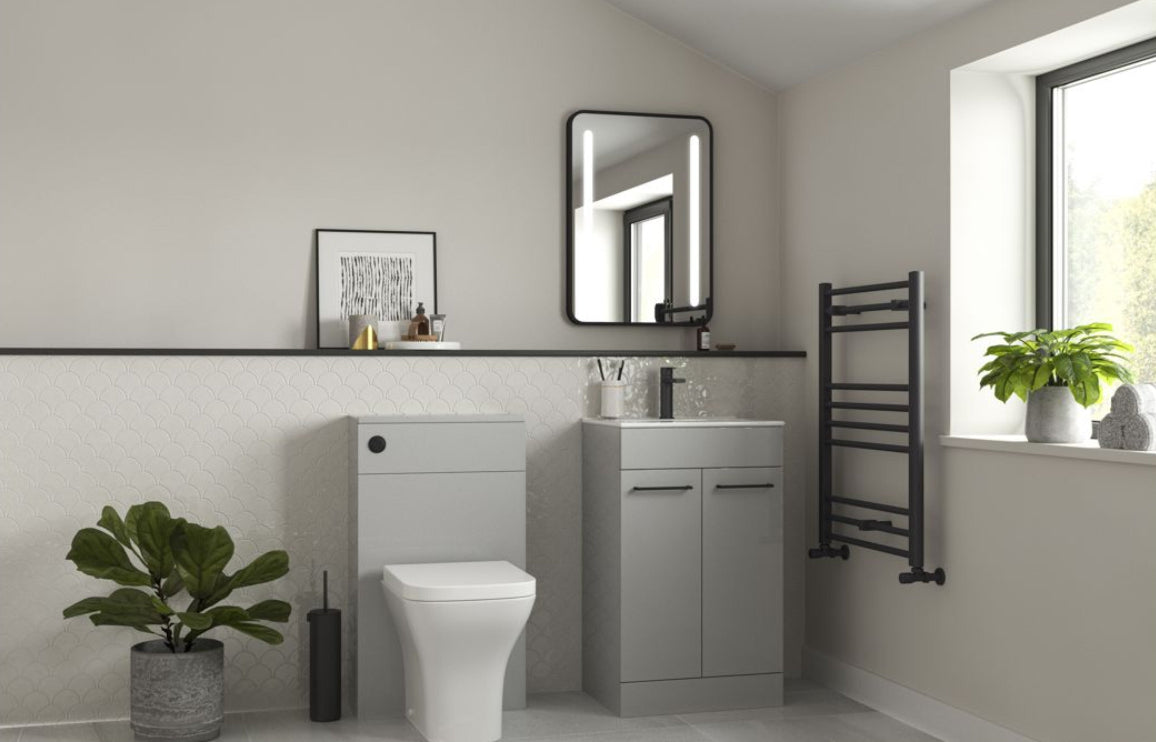 Bathroom interior with gray vanity, toilet, and towel rack.